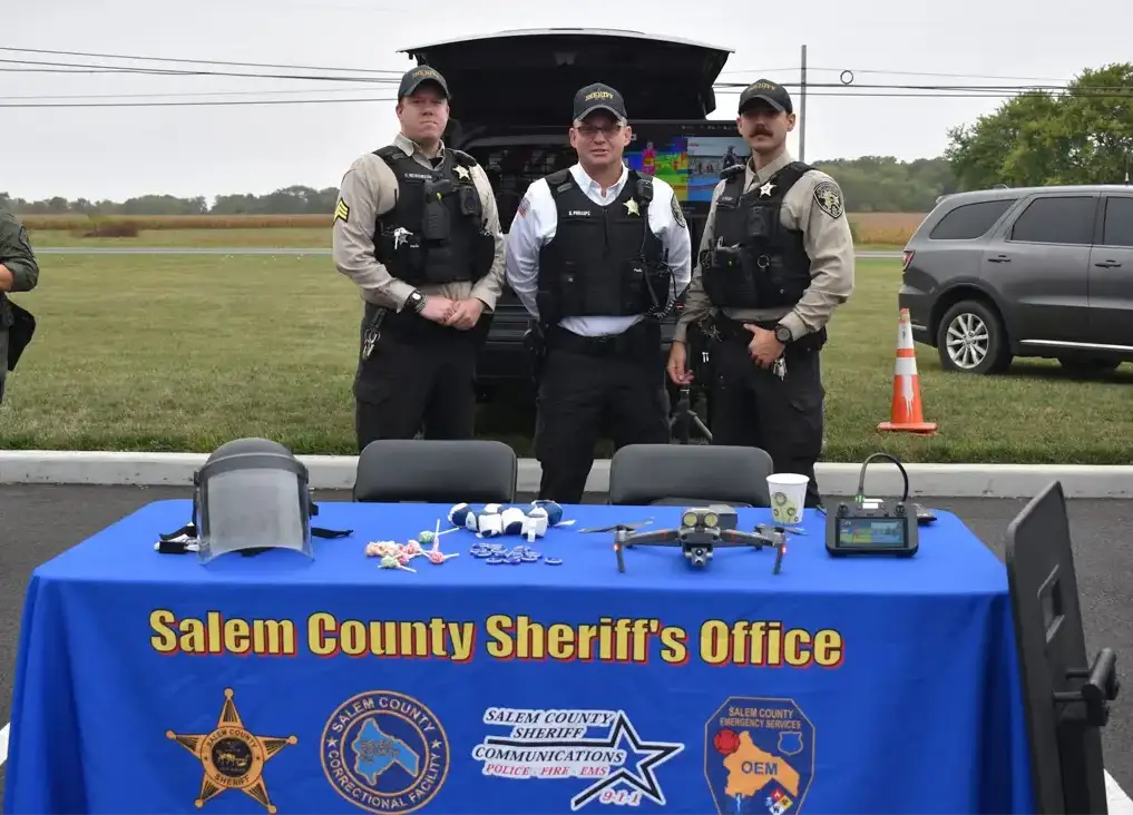 Three officers standing behind table at a Recruitment event